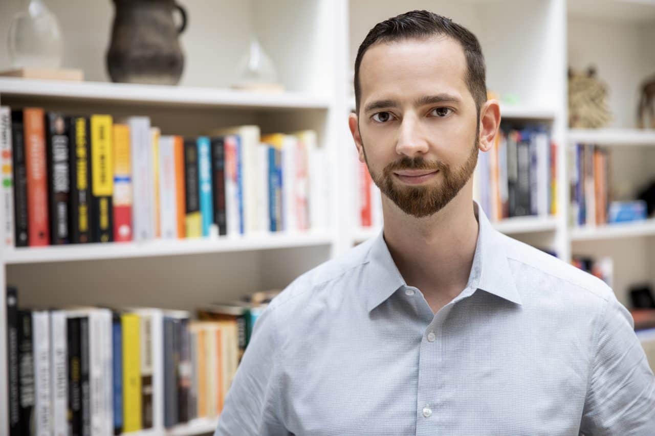 Mikkel Thorup standing in his office in front of books